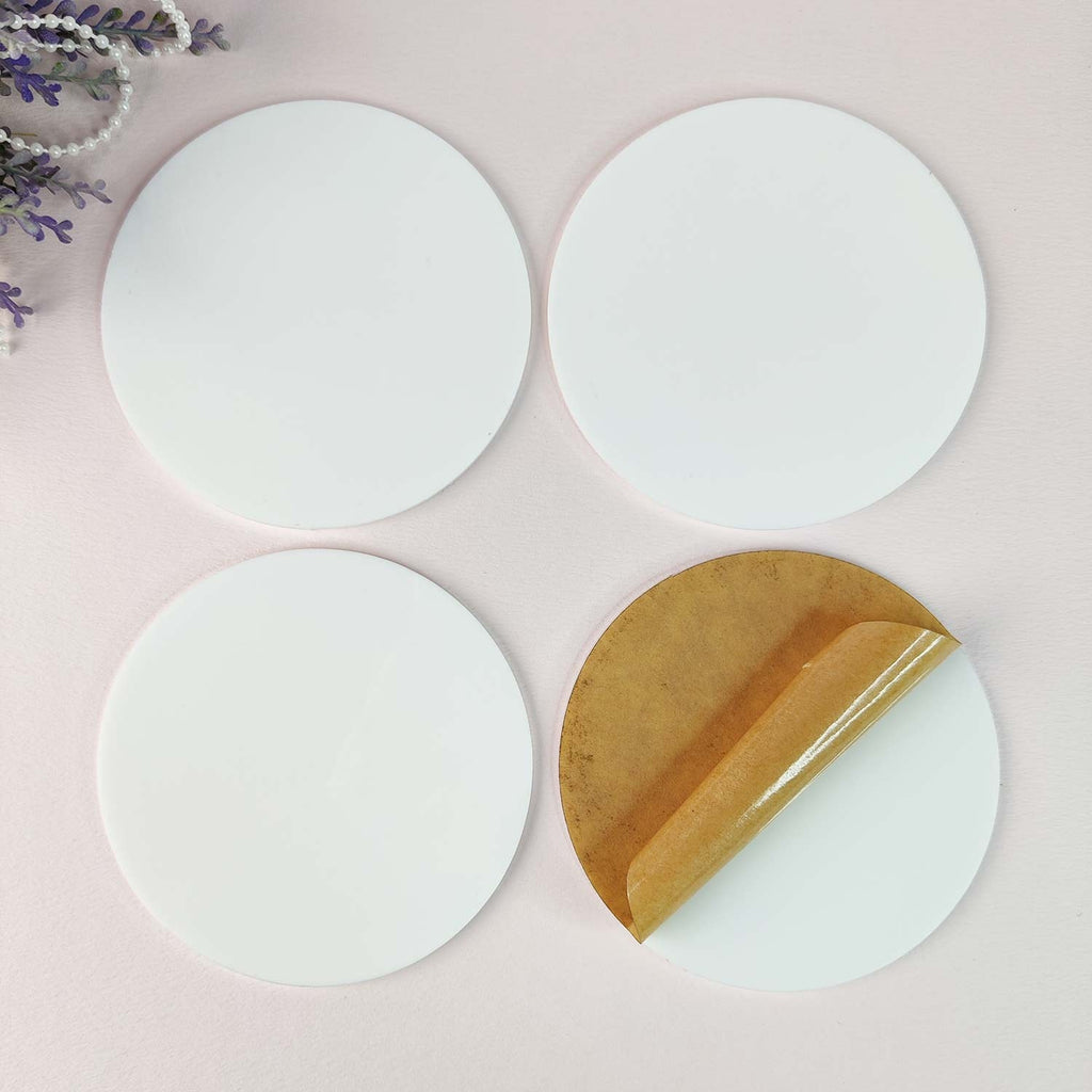 Four white 4" round coasters by Dress My Craft.