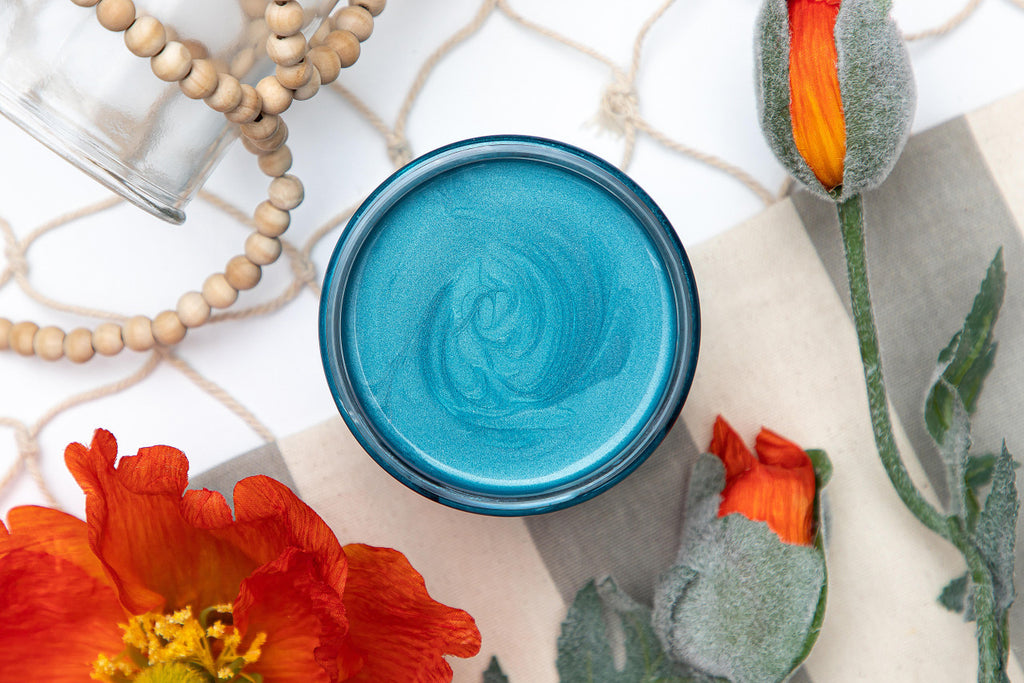 Open Jar of Dixie Belle Moonshine Metallics paint in the color Caribbean, a teal shade.