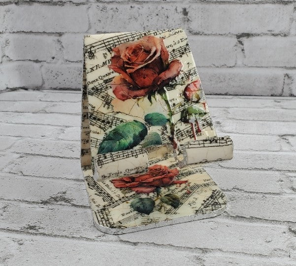 Cell phone holder decoupaged with music notes and roses napkins.