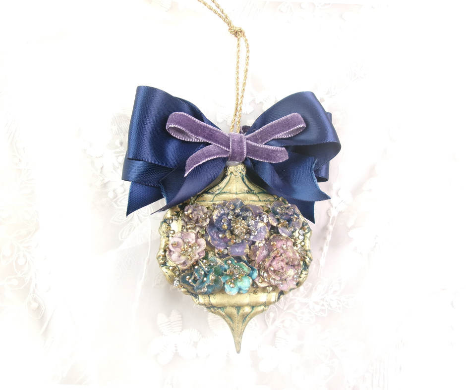 “DIY luxury Christmas ornament with porcelain-look clay flowers, gold accents, and layered navy and lavender ribbon bow—handmade holiday craft using DecoupageNapkins.com supplies.”