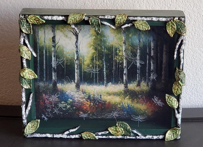 Window box with dragonflies in white birch forest scene.
