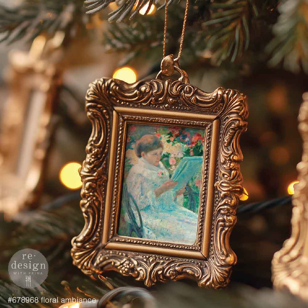 Decorative ornament with ornate gold frame and painting inside, hanging on a Christmas tree.