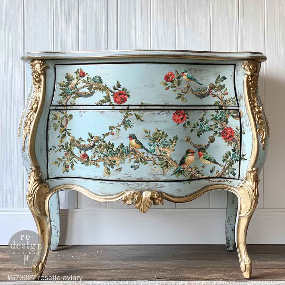 Decorative chest of drawers with floral and bird design on a white paneled wall.