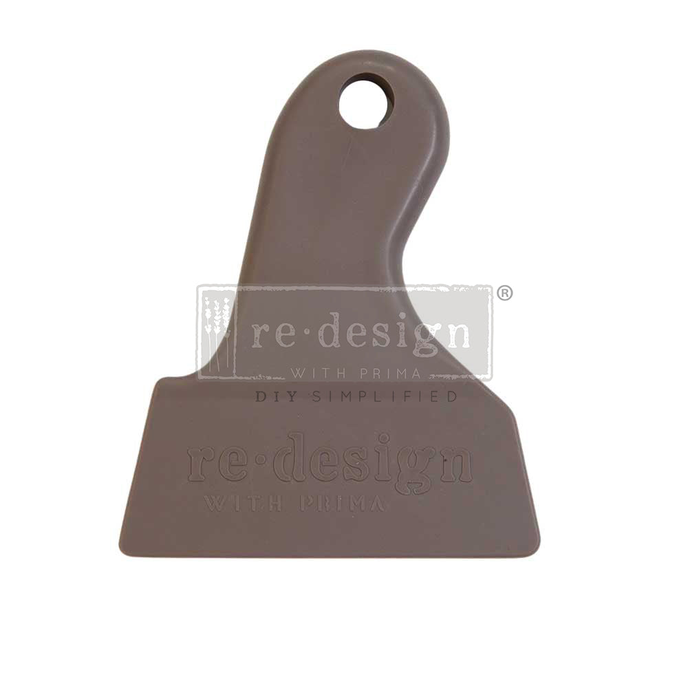 Brown colored silicone Redesign Petite H2O Transfer Scraper Tool, a must-have for any crafter’s toolbox. pairs with Redesign with Prima H2O Transfers