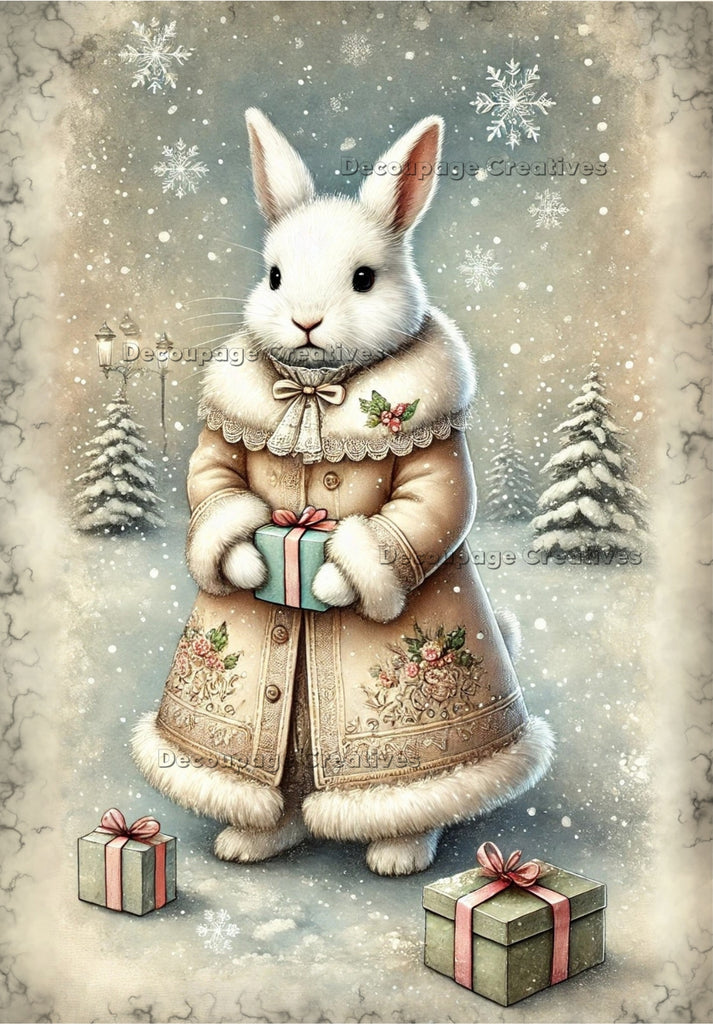 white Rabbit in christmas pink fur coat holding a green present in the snow decoupage rice papers from decoupage creatives