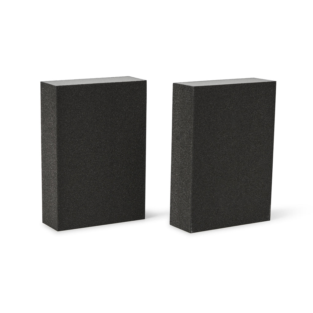 Two black rectangular sanding blocks on a white background