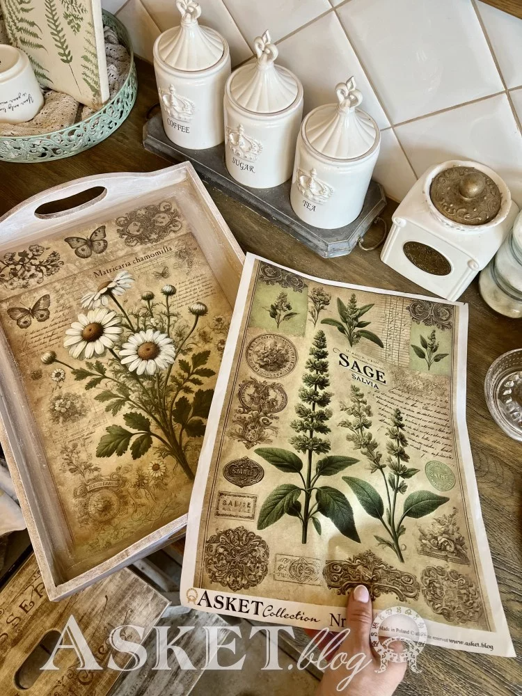 Decorative trays with botanical designs on a wooden surface, featuring the brand 'Asket'.