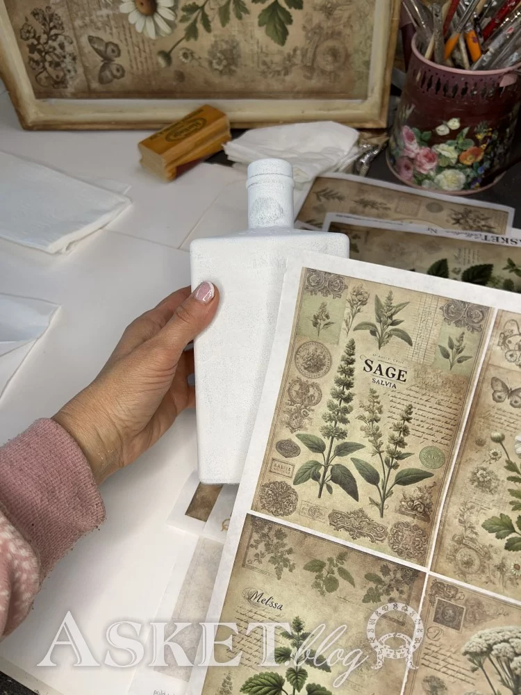 Herbal-themed cards with 'Sage' and other plants, held by a hand, with a blurred background of stationery items.