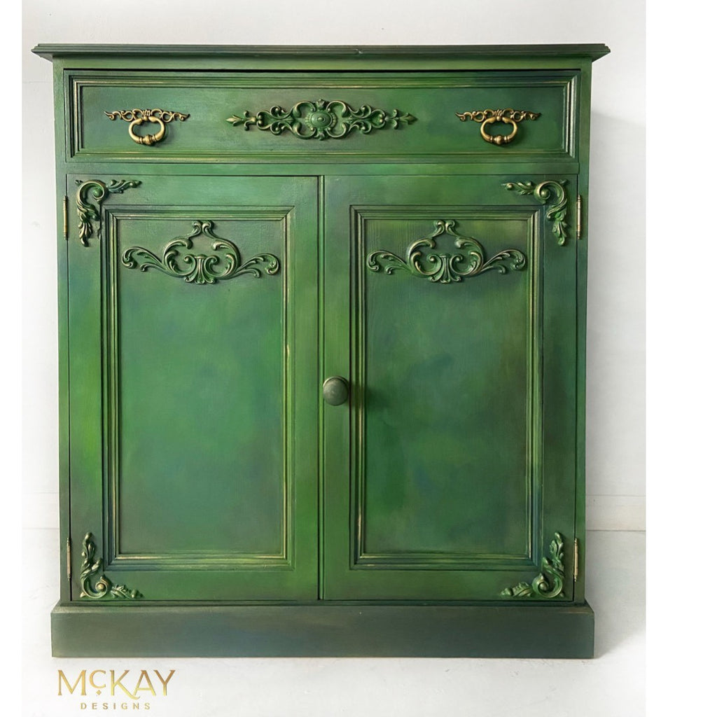 Cabinet painted with Dixie Belle Moonshine Metallics paint in the color Deep Woods, a green shade.