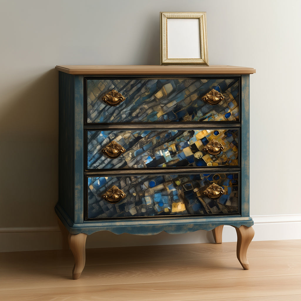 Decorative chest of drawers with mosaic design and gold accents against a neutral wall.