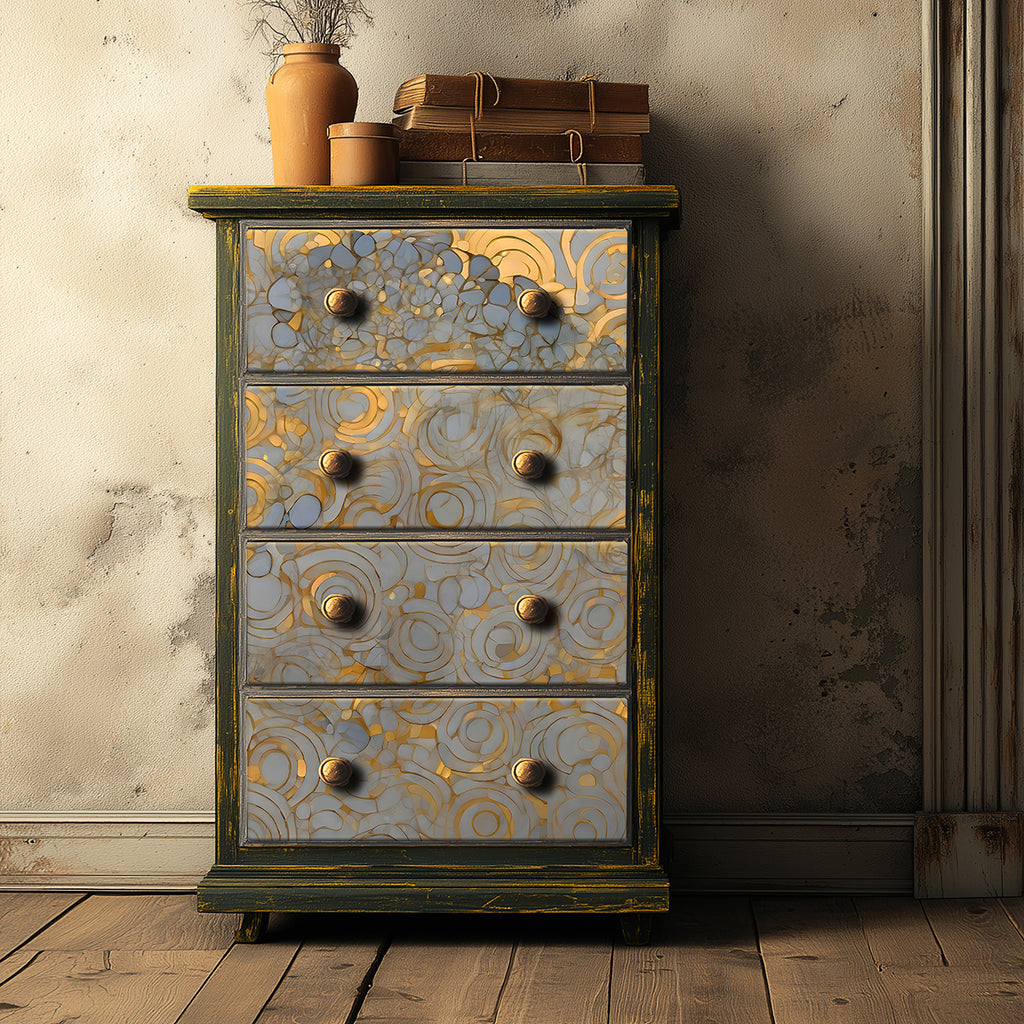 Decorative chest of drawers with gold and silver patterns against a textured wall.