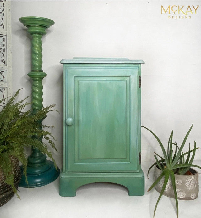 Green cabinet coated in Dixie Belle Glaze in the color of Whitewash