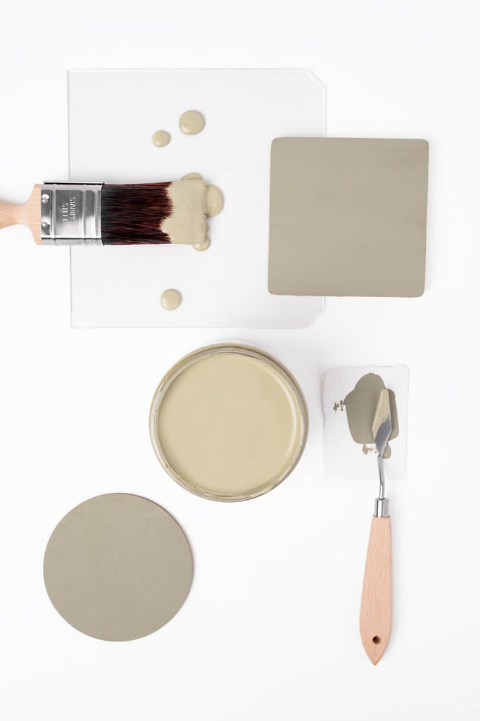 Paint sample with brush, paint container, and tools on a white background
