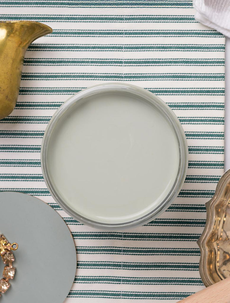 Round gray plate on a striped tablecloth with decorative elements