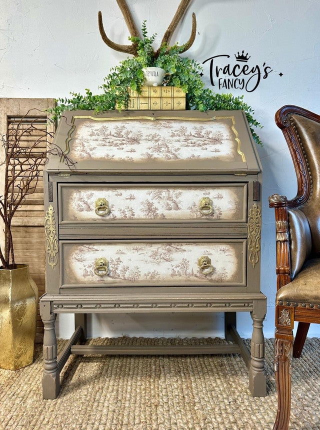 Decorative chest of drawers with gold accents in a room setting, featuring 'Tracey's Fancy' branding.