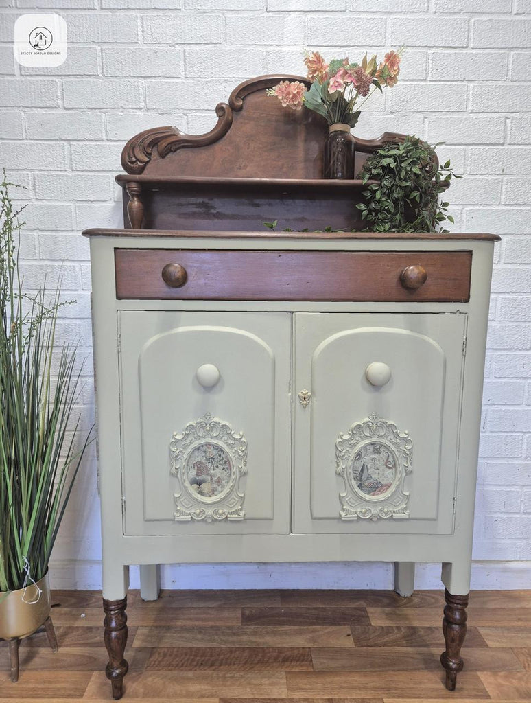 Vintage-style sideboard with decorative elements against a white brick wall.